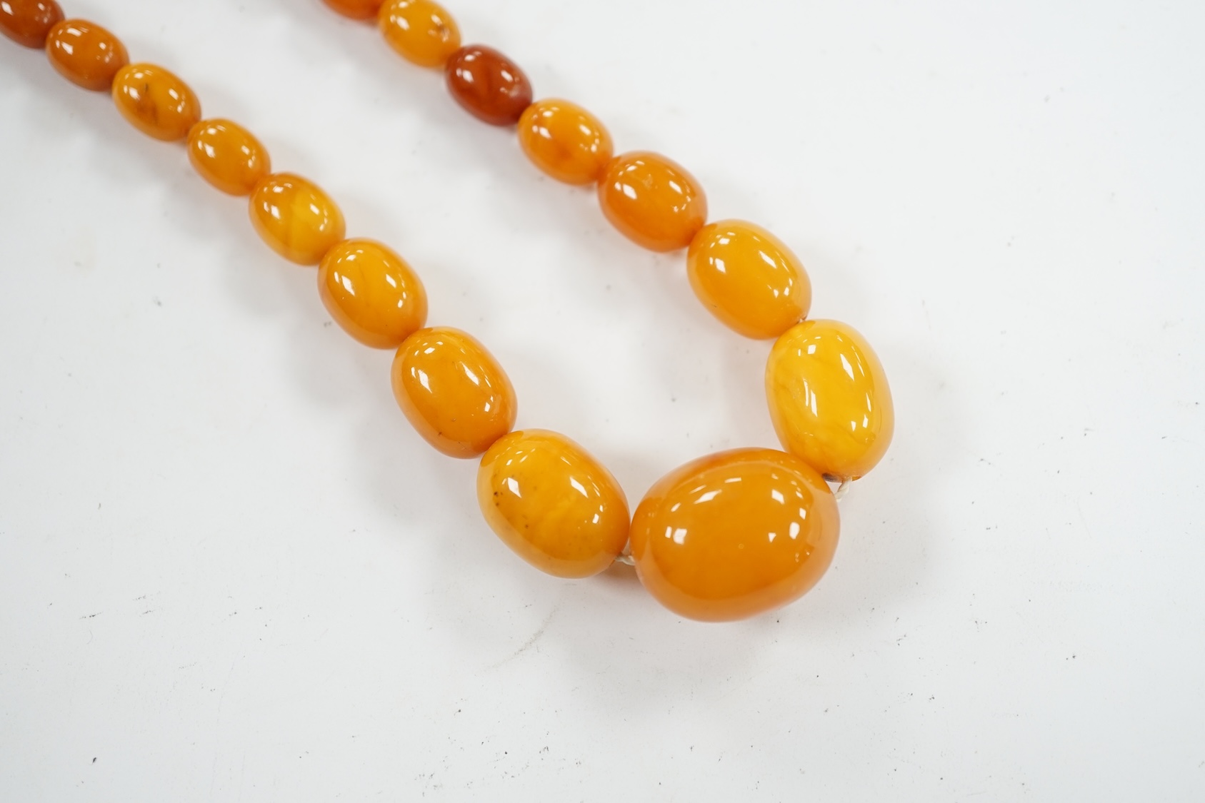 A single strand graduated oval amber bead necklace, 42cm, gross weight 23 grams. Condition - poor to fair